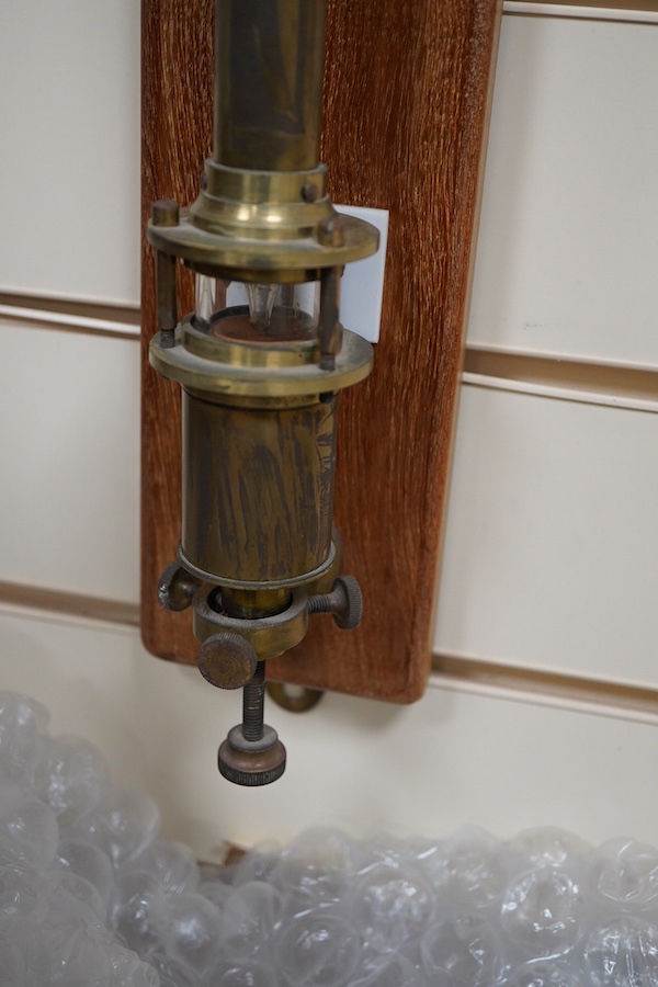 A 20th century lacquered brass marine stick barometer and thermometer by A. Gallenkamp & Co. Ltd., London, with a silvered scale, mounted on a faded oak plaque, 107cm high overall